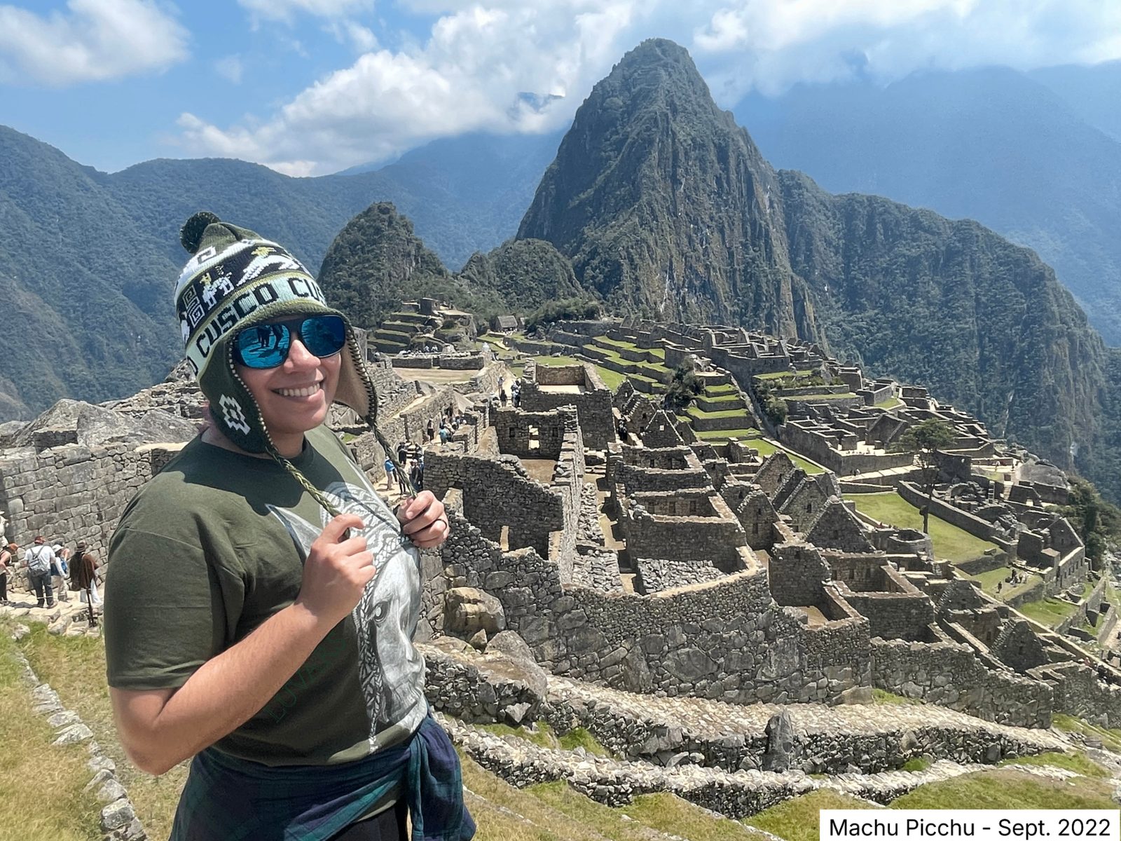 Persona sonriente frente a la ciudadela de Machu Picchu con Huayna Picchu al fondo