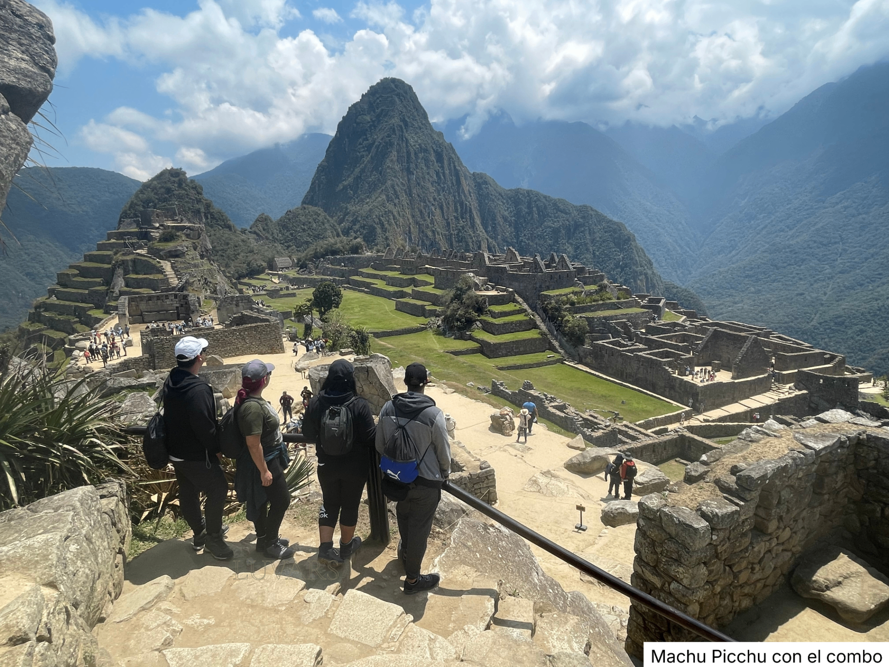 Grupo de amigos contemplando la ciudadela de Machu Picchu desde un mirador